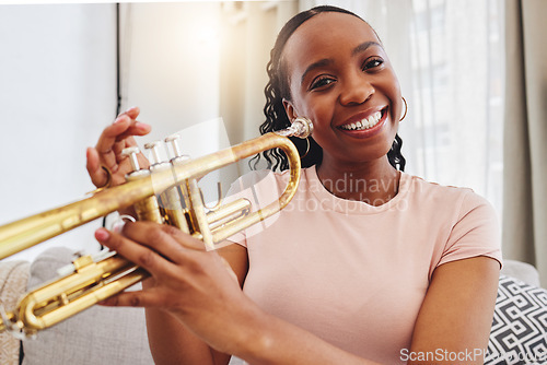 Image of Music, portrait and woman in home with trumpet, smile and band practice for orchestra concert in living room. Art, creativity and jazz culture, happy African musician on sofa with musical instrument.