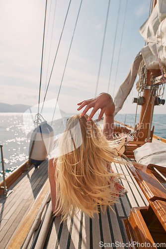 Image of Back, travel and a woman on a yacht for a luxury cruise at sea during summer for a vacation or holiday. Water, view and horizon with a female tourist or traveler sitting on a boat in the ocean