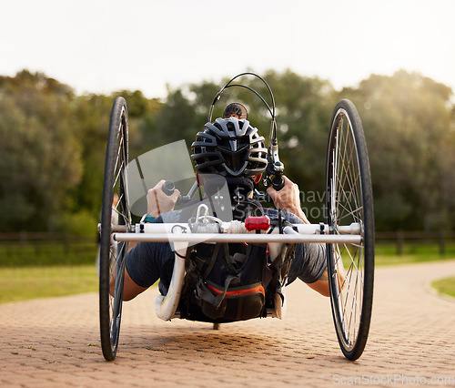 Image of Disability, bicycle and paraplegic person cycling as morning exercise, workout or training for wellness and health. Handbike, sports and person on a wheelchair bike training strength and endurance