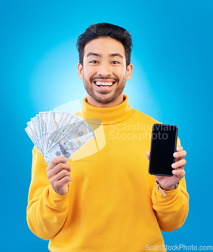 Image of Money, online and prize with portrait and asian man in blue background with for gambling or profit. Cash, winning and guy with fintech mobile app for competition or celebration with dollar in studio.