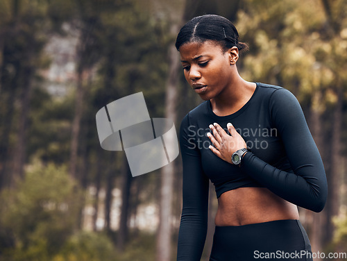 Image of Tired, asthma and black woman athlete with breath problem while running, training or exercise and a chest pain. Cardio, forest and young female person or runner with heart attack risk or injury