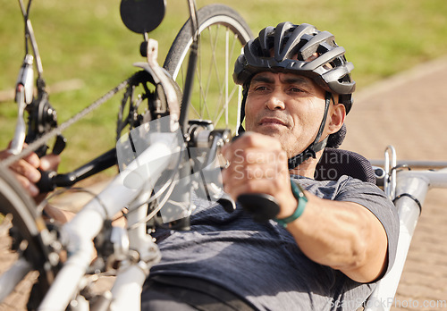 Image of Man with disability, handbike and cycling outdoor for sports, race and endurance contest. Bicycle, male rider and athlete with physical health condition on bike with focus, competition and challenge