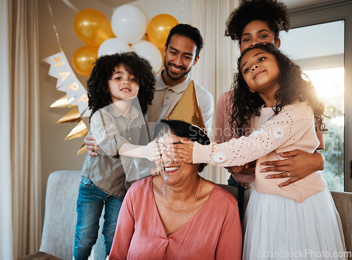 Image of Birthday, surprise and children with grandmother at party in living room for event, celebration and social gathering. Family, celebrate and eyes closed of grandma with happy kids for presents at home