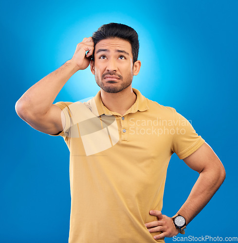 Image of Thinking, ideas and confused man brainstorming promo, problem solving plan or commercial strategy. Planning, space and studio person with questions, decision or doubt choice on blue background