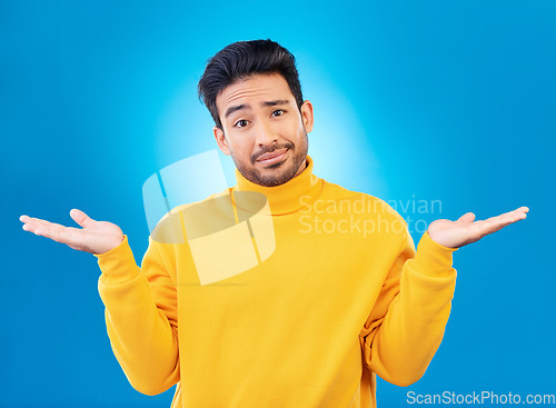 Image of Doubt, shrug and portrait of a man in a studio with a confused hand gesture and facial expression. Uncertain, choice and male model with questions or decision face isolated by a blue background.