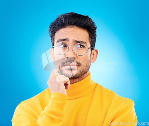 Image of Thinking, face or studio man planning solution, problem solving inspiration or doubt idea, question or confused. Mindset, wonder or person brainstorming options, decision or choice on blue background