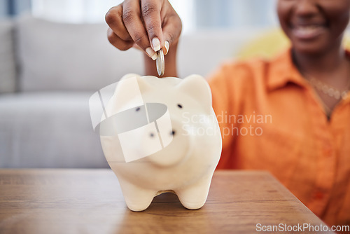 Image of Woman, hands and coin in piggy bank for investment, finance or money savings on table at home. Hand of female person with piggybank for financial freedom, cash growth or budget planning in the house