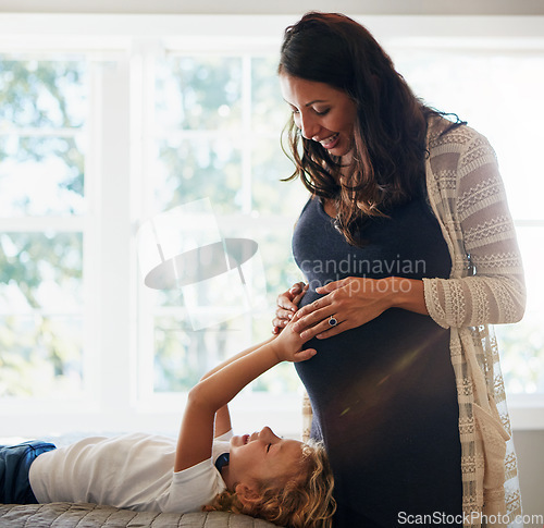 Image of Home bedroom, pregnant woman and child touch, feel or massage stomach to check prenatal fetus movement. Expectation, mother and daughter curious for life growth, pregnancy or baby development on bed