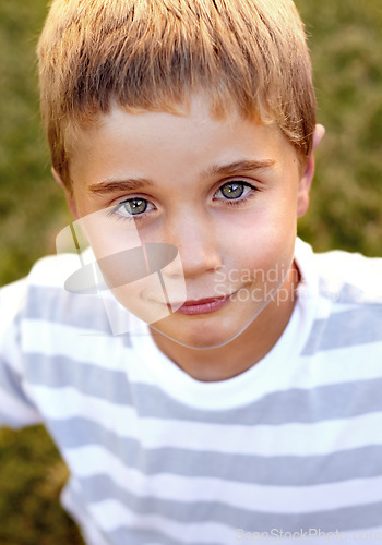 Image of Park, smile and portrait of child on a field to relax on outdoor vacation or holiday and happy boy in a backyard. Confident, freedom and kid calm on a break in nature for fun in summer in garden