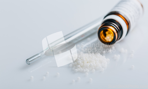 Image of Homeopathic globules in small bottle, homeopathy concept