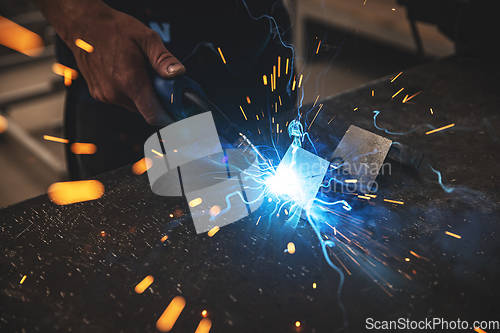 Image of Male worker hand welding steel rack