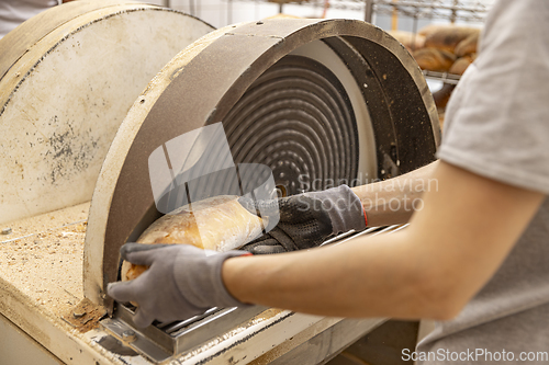 Image of Worker grate bread crust in factory