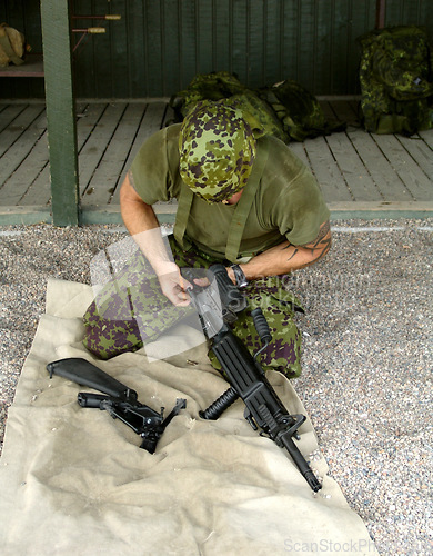 Image of Military, training to assemble a gun with a man soldier outdoor in camouflage uniform for an exercise. Army, blindfold and a trooper person at bootcamp to build a weapon or rifle in record time