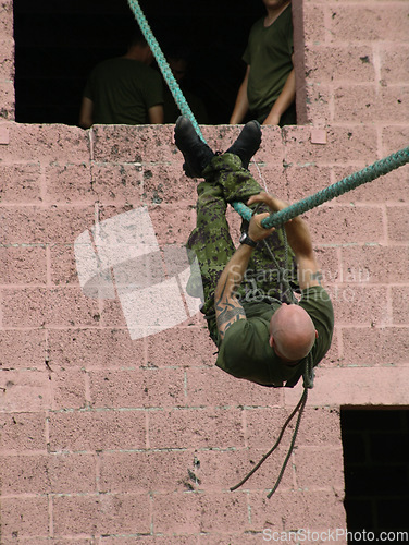 Image of Army, soldier and training with rope obstacle for fitness, exercise or challenge outdoor upside down. Military, man and climbing with physical workout, mission or bootcamp for survival from building