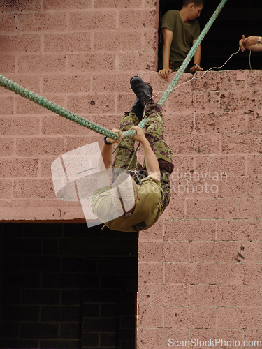 Image of Obstacle, soldier and training with rope climbing for fitness, exercise or challenge outdoor with gear. Military, people and upside down for workout, mission or bootcamp with camouflage for survival