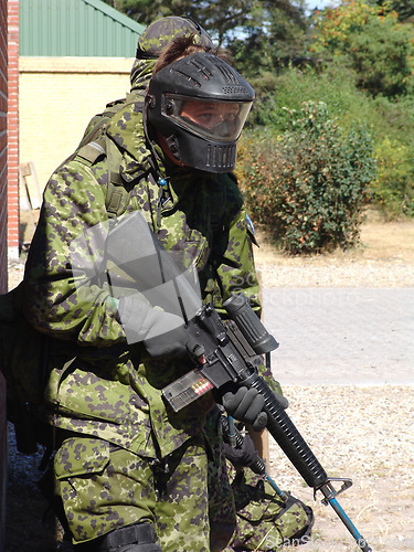 Image of Soldier, man and target by building with weapon for fitness, exercise or challenge outdoor with gear. Military, person or battle for workout, mission or bootcamp with camouflage or mask for survival