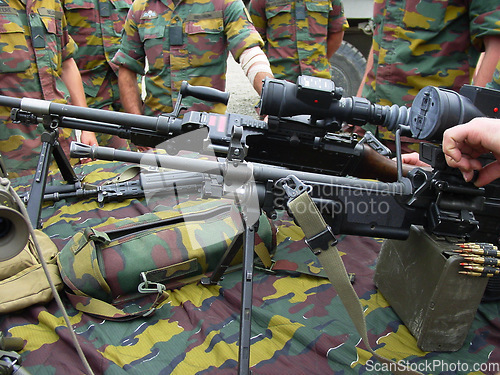 Image of Machine, gun and hands of man in military, gear and training for war, artillery and ammunition. Army, soldier and men in group together at bootcamp, mission or outdoor with auto technology for battle