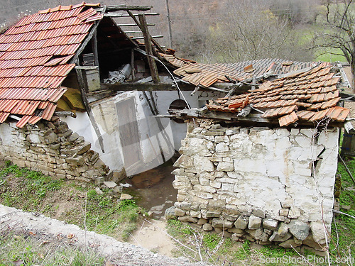 Image of Abandoned, house and outdoor with war, ruins and destruction of countryside property from bomb. Warzone, building or broken roof damage on home or cottage shed in rural, farm or woods in nature