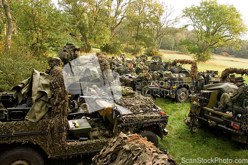 Image of Soldier, vehicle and military with people in the forest together, getting ready for an ambush during war on the battlefield. Army, training and camouflage with an infantry group on a field of grass