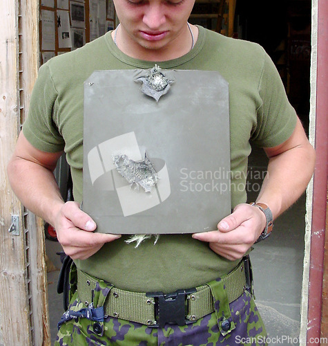 Image of War, damage and man with bullet proof armor with holes for army or military warzone training. Conflict, metal and closeup of male warrior or soldier with equipment for protection from shooting.