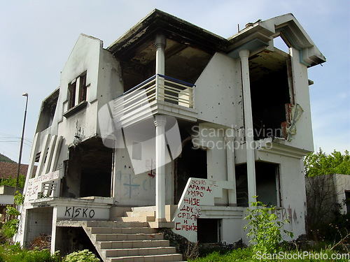 Image of Abandoned, house and outdoor with war, ruins and destruction of countryside property from bomb disaster. Warzone, land or rubble of grunge apartment, building or old home with graffiti on wall