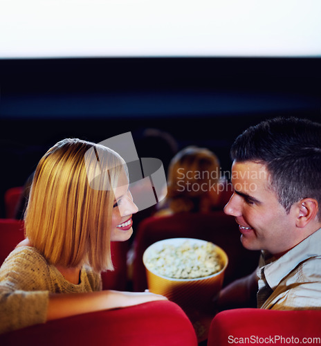 Image of Cinema, smile and couple with popcorn, watching film or eating on romantic date together. Movie night, happy man and woman in theater with snacks, love and sitting in auditorium to relax in audience