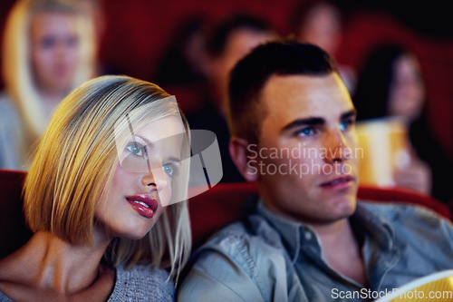 Image of Cinema, movie and couple watching film, entertainment and popcorn on romantic evening together. Date night, man and woman in Hollywood theater with snacks, show and sitting in auditorium to relax.