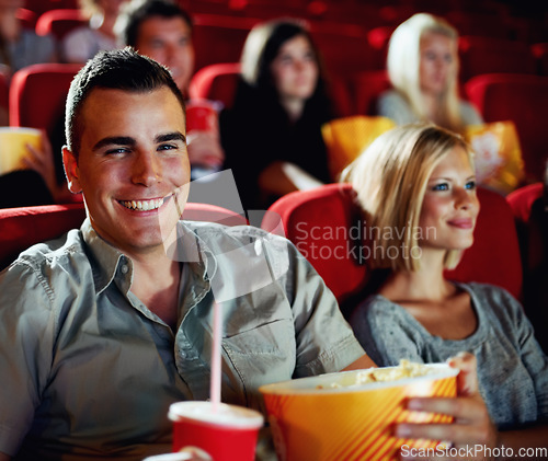 Image of Cinema, portrait and happy couple with popcorn, watching film and romantic date together. Movie night, man and woman in theater show with snacks, drink and smile in auditorium to relax in audience.