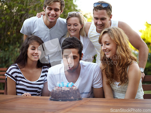 Image of Birthday, people and blow candles outdoor for celebration, surprise or party with milestone or happiness. Cake, men and women in backyard of home or nature with gathering or social event with smile