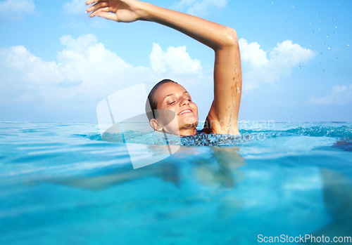 Image of Woman, swimming and sea with smile, relax and sea water in summer on vacation with travel. Happy, adventure and holiday with freedom in Hawaii with fitness in a ocean outdoor with calm female person