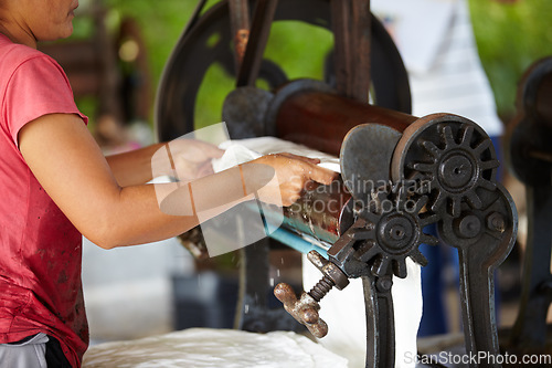 Image of Rubber, farming and hands of person with roller in workshop, factory and agriculture warehouse. Manufacturing, production with worker machine for rolling latex, plastic and material plantation