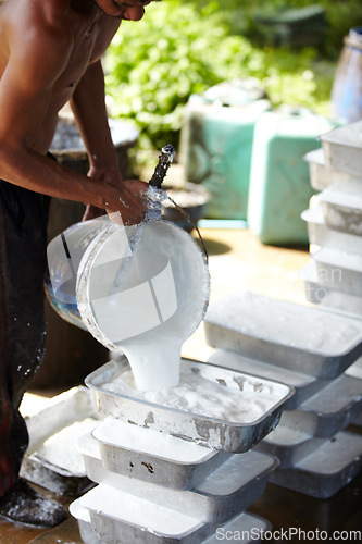 Image of Rubber, farming and person with container in workshop, factory and production warehouse. Plantation, agriculture and worker with bucket for labour, plastic and material manufacturing in Thailand