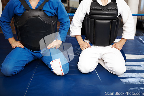 Image of Karate, people and kneeling, exercise with fight in ring and martial arts, protection vest with discipline and ready for battle. Fitness, warrior and muay thai with challenge in gym for taekwondo