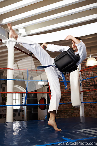 Image of Man, karate and high kick in training, self defense or jiujitsu for martial arts or fighting match. Male person, athlete or fighter in MMA boxing, muay thai or fitness practice at dojo or gym ring