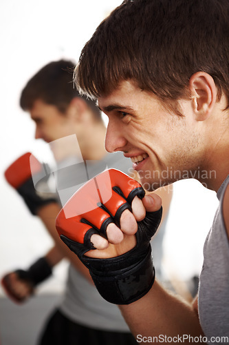 Image of Man, martial arts and fitness, fist and fight with kickboxing, MMA and battle, power and athlete in gym. Exercise, combat sport and boxing with strong boxer in club, workout and training with glove