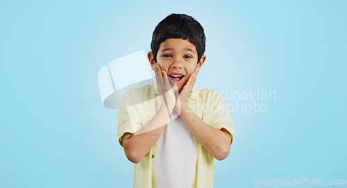 Image of Smile, kid and hands on face for surprise in studio isolated on a blue background mockup space. Portrait, wow and happy child shocked at good news, promo announcement and excited facial expression