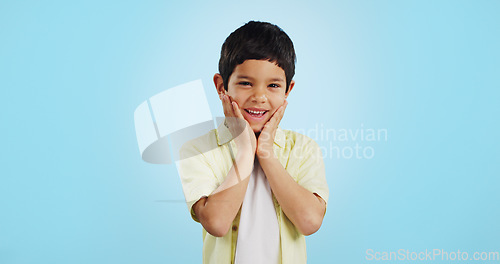 Image of Excited, kid and hands on face for surprise in studio isolated on a blue background mockup space. Portrait, wow and happy child shocked at good news, information announcement and facial expression.