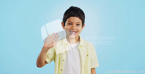 Image of Kid, hand and waving with smile in studio on blue background in mockup with excitement. Youth, boy and greeting while looking at screen with face for announcement of offer on social media, web or app