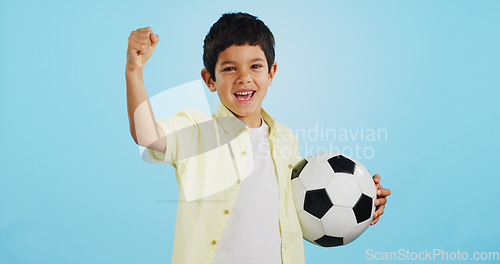 Image of Winner, soccer ball or face of child in studio with smile, joy or happiness for sports success, score or goal. Happy boy, portrait or excited kid with fist or football on blue background mockup space