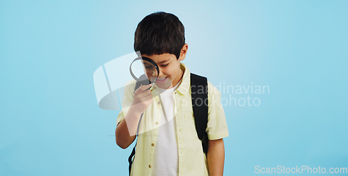 Image of Search, looking and a child with a magnifying glass on a blue background for inspection or education. Studying, learning and a boy kid with tools for research, detective work or curious with a lens