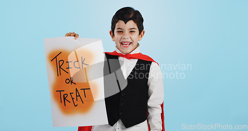 Image of Halloween, poster and portrait of child with paper board for candy isolated in a studio blue background and happy. Holiday, laughing and kid in vampire costume for celebration in fantasy festival