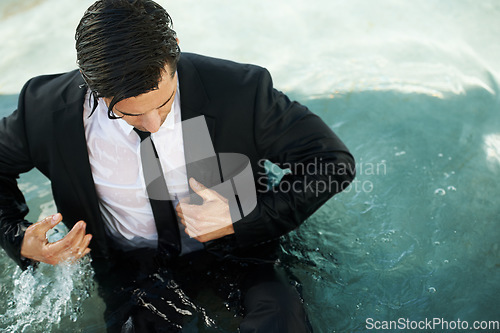 Image of Water, pool and a business man in debt during depression of the economy or financial crisis. Finance, challenge and unemployment with a young corporate employee wet in a suit during recession