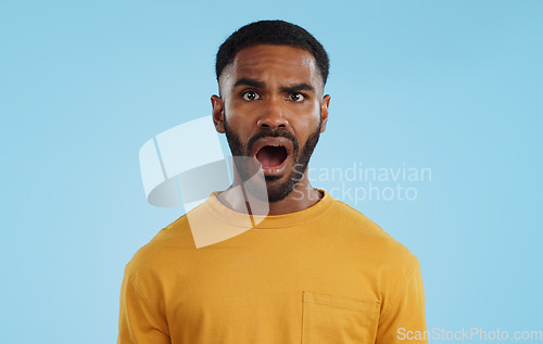 Image of Face, surprise and man with gossip, news and announcement on a blue studio background. Portrait, person and model with shock, expression and mockup space with wow, omg and emoji with secret and icon