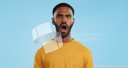 Image of Face, surprise and man with gossip, news and announcement on a blue studio background. Portrait, person and model with shock, expression and mockup space with wow, omg and emoji with secret and icon