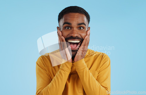 Image of Hands on face, wow and excited black man in studio isolated on a blue background mockup space. Portrait, surprise and happy person in shock for good news, information and winner of bonus promotion