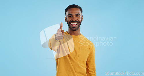 Image of Face, smile and man with thumbs up in studio for support, motivation or vote on blue background. Happy, portrait and excited male model with hand emoji for winning, thank you or success gesture