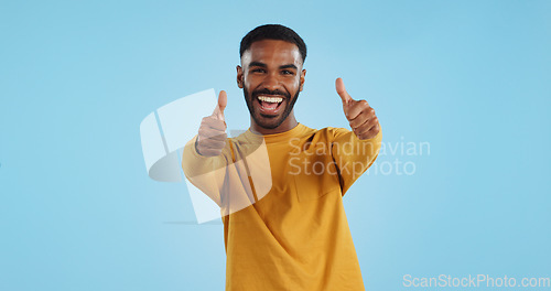 Image of Happy, face and man with thumbs up in studio for support, motivation or vote on blue background. smile, portrait and excited male model with hand emoji for winning, thank you or success gesture