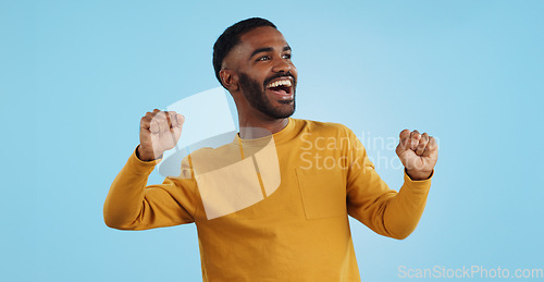 Image of Dance, man and excited for party in studio to celebrate success, promotion and winning lotto on blue background. Happy young model, giveaway winner and energy for disco, groovy music and freedom