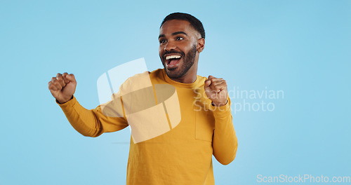 Image of Dance, man and excited for party in studio to celebrate success, promotion and winning lotto on blue background. Happy young model, giveaway winner and energy for disco, groovy music and freedom