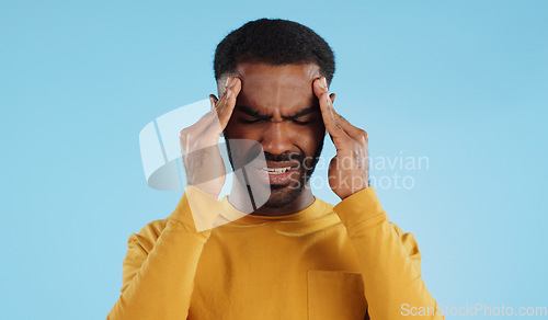 Image of Stress, tired and a man with headache pain on a blue background from burnout or anxiety. Mental health, fatigue and a person with a migraine massage, frustrated and with depression and anger